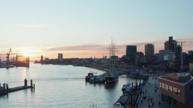 İnsanlar Hamburg, Almanya 'da Elbe nehri kıyısında akşam yürüyüşünün keyfini çıkarıyorlar.