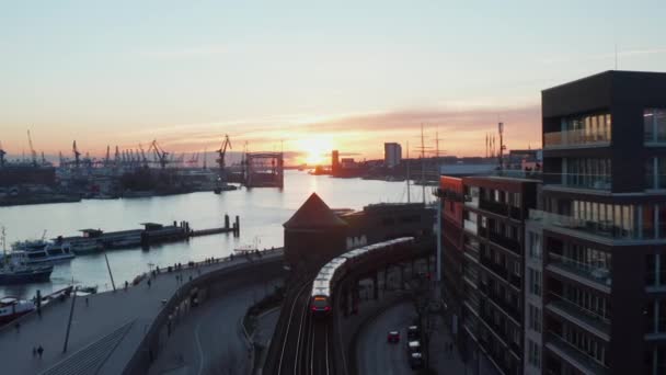 Akşam Hamburg şehir merkezinde Elbe nehrinin yanından geçen bir trenin hava görüntüsü. — Stok video