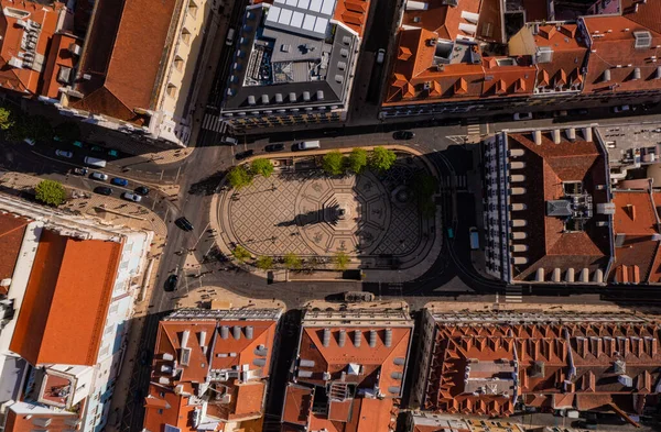 Lizbon, Portekiz 'deki kasaba meydanının en aşağı manzarası. Süslerle dekoratif zemin ve yol kenarında sekizgen kaidede heykel..
