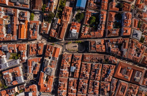 Şehrin tarihi merkezindeki kırmızı binaların tam üstünde. İHA 'dan evler ve sokaklar, Lizbon, Portekiz.