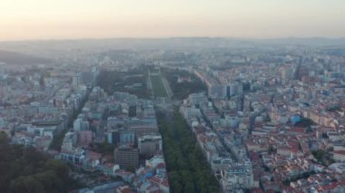 Geniş panoramik yan açıyla Lizbon şehir merkezindeki büyük yemyeşil halk parkı olan konut evlerinin çatıları görülüyor.