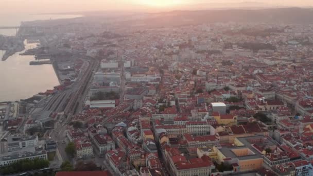 Vista deslizante aérea de belos raios de sol sobre o centro da cidade de Lisboa com casas coloridas e marcos famosos no centro da cidade velha — Vídeo de Stock