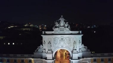 Arco da Rua Augusta 'nın Praca do Comercio Meydanı' ndaki anıtını ve Lizbon şehir merkezindeki evleri gece görüş alanında kapatın.