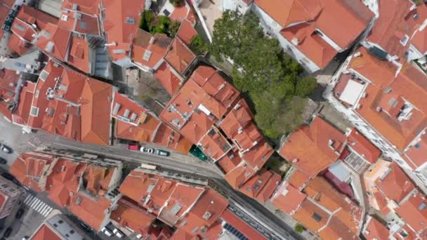 Aerial overhead top down view of orange rooftops and streets between small colorful houses in dense urban city center of Lisbon, Portugal — Stock video