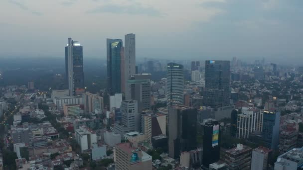 Vuelo en avión no tripulado hacia adelante sobre los edificios del vecindario del centro de la capital de México con antecedentes de rascacielos de negocios. Zoom aéreo a la vista. — Vídeo de stock
