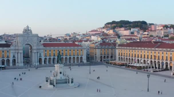 Aerial ascending view of people on Praca do Comercio public square in Lisbon with Arco da Rua Augusta and residential houses in the background — Video