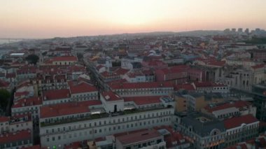 Lizbon şehir merkezindeki geleneksel eski evlerin renkli çatıları. Arka planda Ponte 25 de Abril kırmızı köprüsünün görüntüsü var.