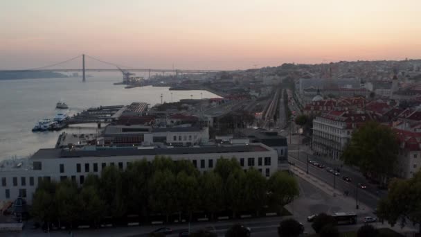 포르투갈 리스본 해안에서 저녁에 여러 차선 버스와 차량이 다니는 모습 이보이는데, 뒤에 보이는 것은 폰테 25 드 아브 리알 레드 브리지 — 비디오