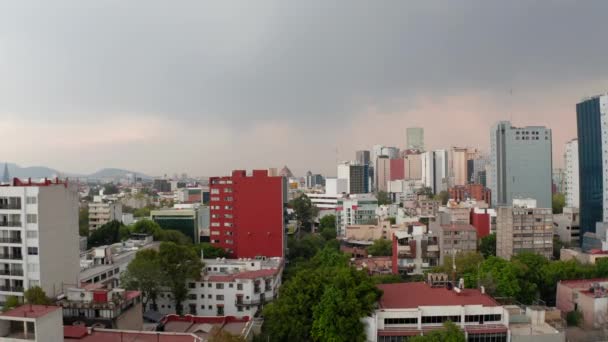 Avance o voo do drone sobre os edifícios da vizinhança do centro da capital do México com fundo dos arranha-céus de negócios. Zoom aéreo em vista. — Vídeo de Stock