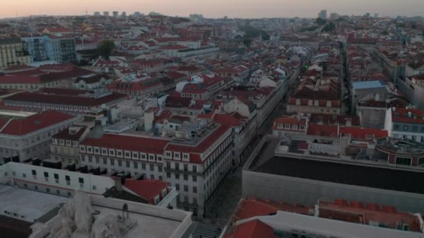 Vista aérea de tejados rojos de casas coloridas en el centro de Lisboa y el monumento Arco da Rua Augusta en la ciudad europea tradicional — Vídeo de stock