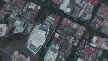 Havadan kuşların gözü tepeden aşağı şehirdeki binanın manzarasında. Sokaklar ve bloklar üzerinde uçan insansız hava aracı kamerası. Mexico City, Meksika.