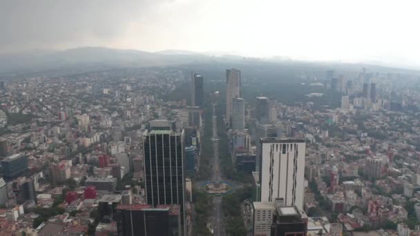 Flygfoto över raka boulevarden omgiven av höga moderna kontorsbyggnader. Kamera visa snabbt luta ner till toppen ner vy över gatan. Mexico City, Mexiko. — Stockvideo