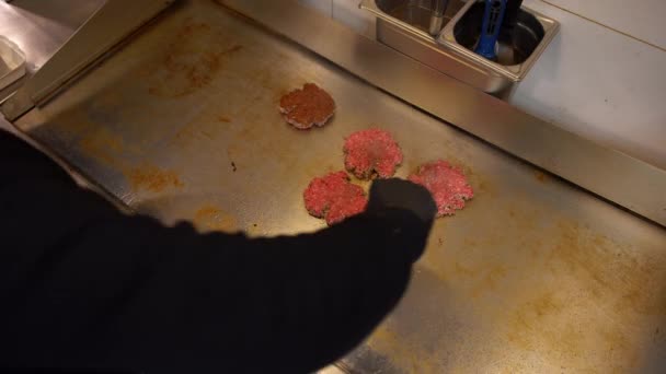 Profesjonalny kucharz przerzucanie burger mięso patty w kuchni restauracji. Widok nad głową burger mięso paszteciki gotowanie na płycie grzewczej — Wideo stockowe