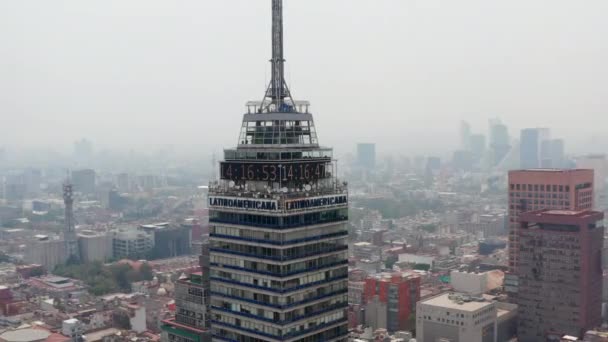 Vista aérea del edificio alto Torre Latinoamericana. Cámara volando alrededor de la parte superior del rascacielos, paisaje urbano en el fondo. Ciudad de México, México. — Vídeos de Stock