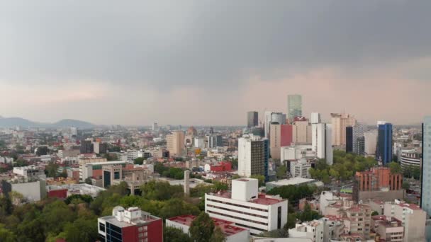 Vista aerea di alta varietà di edifici in centro. Case colorate alternate a alberi verdi. Fotocamera a drone volante all'indietro, cielo coperto prima della pioggia. Città del Messico, Messico. — Video Stock