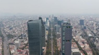 Büyük şehir manzarasının havadan görüntüsü. Modern yüksek ofis binalarının arasına uzanan geniş, düz bir caddeye bakan kamera. Mexico City, Meksika.