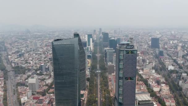 Αεροφωτογραφία του μεγάλου αστικού τοπίου της πόλης. Κάμερα γέρνει προς τα κάτω σε μεγάλη ευθεία δρόμο που οδηγεί μεταξύ των σύγχρονων ψηλών κτιρίων γραφείων. Πόλη του Μεξικού, Μεξικό. — Αρχείο Βίντεο