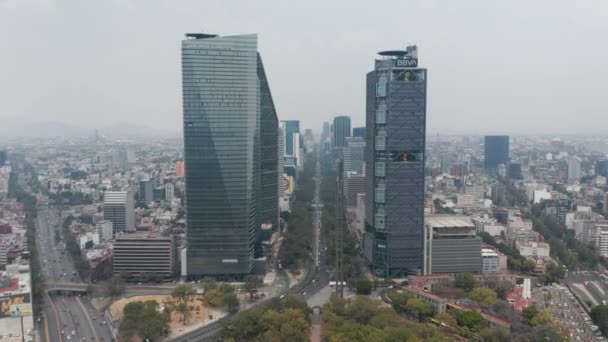 Drönare flyger framåt från Chapultepec park mellan höga moderna kontorsbyggnader på breda Avenida Paseo de la Reforma gatan. Mexico City, Mexiko. — Stockvideo