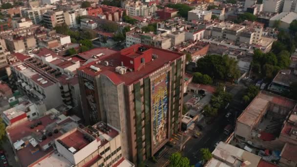 Luftaufnahme verschiedener Gebäude in einer Wohnsiedlung. Drohne fliegt vor und Kamera verfolgt hohes Wohnhaus mit rotem Flachdach. — Stockvideo