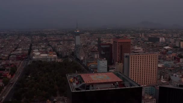 Cámara de drones volando por encima del rascacielos con helipuerto. Vista aérea del paisaje urbano después del atardecer. Ciudad de México, México. — Vídeo de stock