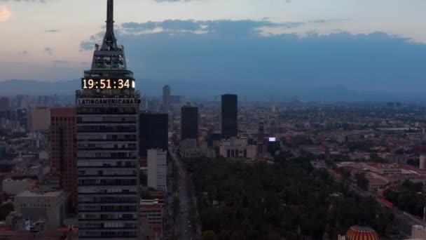 Pandangan pesawat tak berawak dari gedung tinggi Torre Latinoamericana. Kamera terbang di sekitar gedung pencakar langit, pemandangan kota setelah matahari terbenam di latar belakang. Mexico city, Mexico. — Stok Video