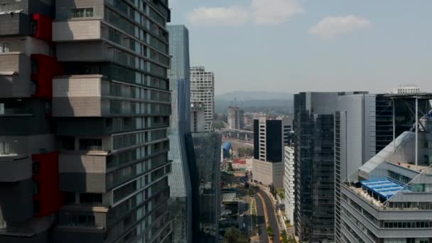 Yüksek binalarla kaplı geniş cadde manzarası. İnsansız hava aracı modern gökdelenler arasında yol üstünde uçuyor. Mexico City, Meksika. — Stok video