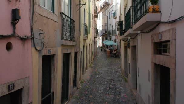 Point of view street view of walking on the cobblestone streets in Lisbon, Portugal with people sitting and chatting in local cafes — Stock Video