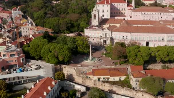 Muñeca aérea en vista de la fuente de agua Chafariz das Necessidades por la iglesia en el centro urbano de Lisboa, Portugal — Vídeo de stock