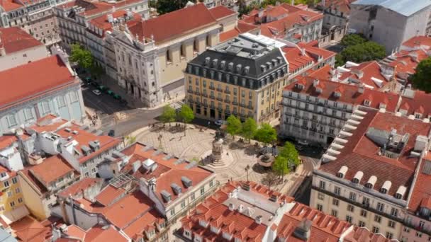 Vzdušná oběžná dráha památníku a žluté tramvaje kolem náměstí obklopená tradičními barevnými domy v centru Lisabonu — Stock video