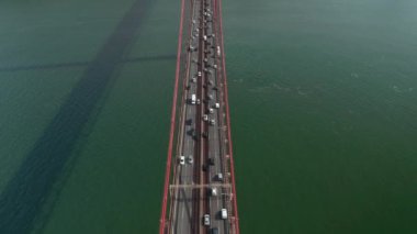 Lizbon, Portekiz 'deki 25. de Abril Köprüsü' ndeki büyük kırmızı süspansiyonda yoğun bir trafiğin ardından havadan genel bir görüntü.