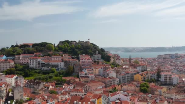 Aerial dolly in view of old castle on the hill above colorful houses in Lisbon urban city center — Stock Video