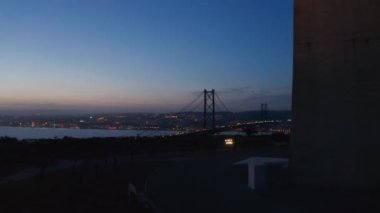 Gün batımından sonra kablo destekli köprünün hava manzarasını yavaş yavaş gözler önüne seriyor. Drone 'dan Gece Köprüsü silueti. Lizbon, Portekiz 'in başkenti.