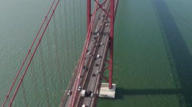 Kalabalık saatlerde çok şeritli otobanda yoğun trafiğin havadan görüntüsü. İnsansız hava aracı Tagus nehri boyunca büyük bir köprünün üzerinde uçuyor. Lizbon, Portekiz 'in başkenti.