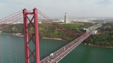25 Nisan Köprüsü 'nün güney ucunda Lizbon ve Almada' yı bağlayan hava aracı görüntüsü. Kalabalık saatte çok şeritli yolda yoğun trafik var. İsa 'nın heykeli kaidede. Lizbon, Portekiz 'in başkenti.