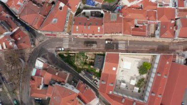 Hava kuşları tepeden aşağı eski şehir merkezinin dar sokaklarındaki düşük trafiği görüyorlar. Tramvay durağında duran tarihi tramvay. Lizbon, Portekiz 'in başkenti.