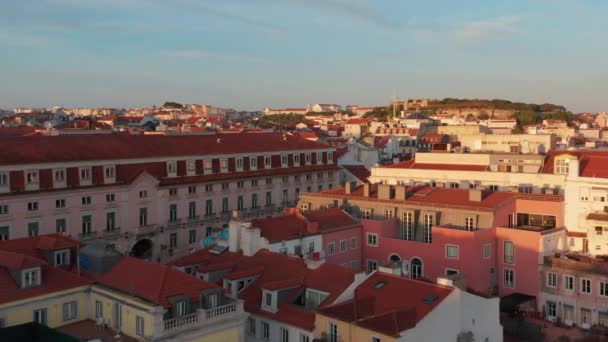 Elevated evening view of bright sun illuminated buildings downtown. Drone flying over red rooftops. Lisbon, capital of Portugal. — Stock Video