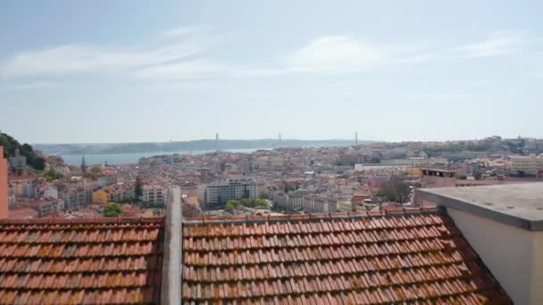 Drone camera flying over red tiled roof. Wide city panorama reveals behind roof ridge. Lisbon, capital of Portugal. — Stock Video