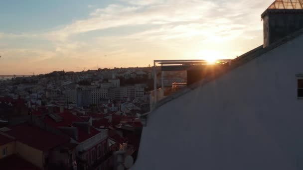 夕日に対する建物のシルエット。穏やかな夜の空中ドローンビュー。雲とカラフルな夕日の空。ポルトガルの首都リスボン. — ストック動画