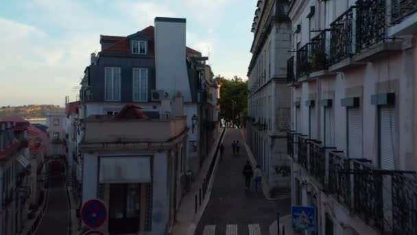 Telecamera drone che vola attraverso la stretta strada nel centro della città. Serata di riprese elevate. Lisbona, capitale del Portogallo. — Video Stock