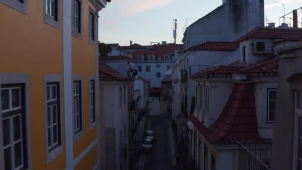 Lentävä lennokkikamera rakennusten välillä illalla keskustassa. Korkeat näkymät vanhoja taloja vuori kapeita katuja. Lissabon, Portugalin pääkaupunki. — kuvapankkivideo