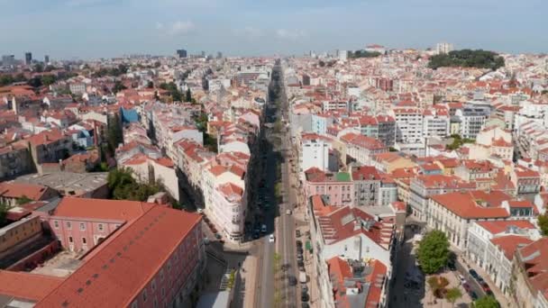 Vista aérea de drones de larga calle recta en la ciudad. Cámara inclina hacia abajo y se acerca a la casa en la esquina de la calle afilada. Lisboa, capital de Portugal. — Vídeo de stock