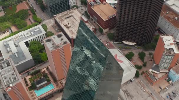 Vue en angle élevé de la crête pointue sur le dessus du haut bâtiment de forme inhabituelle recouvert de verre. Vue aérienne par drone de la place de la Fontaine. Dallas, Texas, USA — Video