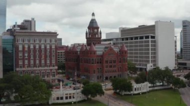 Kulesi ve az sayıda kulesi olan tarihi şato tarzı bir bina manzarası. Dallas 'ın eski Kırmızı Müzesi şehir merkezindeki modern çok katlı ofis blokları arasında. Dallas, Teksas, ABD