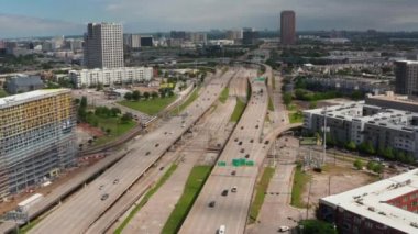Çok şeritli otoyol üzerinde kavşağa doğru uçan bir dron. Trafiğin yoğun olduğu saatte. Şehirden geçen ana yolun havadan görüntüsü. Dallas, Teksas, ABD