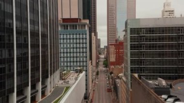 Yüksek binalarla cadde boyunca insansız hava aracı uçuruyor. Şehir merkezinin havadan Comerica Bank Tower 'a bakan görüntüsü. Çevredeki binaların çeşitli yükseklikleri. Dallas, Teksas, ABD