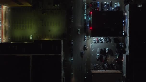 Pájaros aéreos ojo por encima de la cabeza vista de arriba hacia abajo de amplias calles multicarril del centro. Drone siguiendo a coche conduciendo a través de cruce de caminos. Vista nocturna panorámica vertical de calles iluminadas. Dallas, Texas, EE.UU. — Vídeo de stock