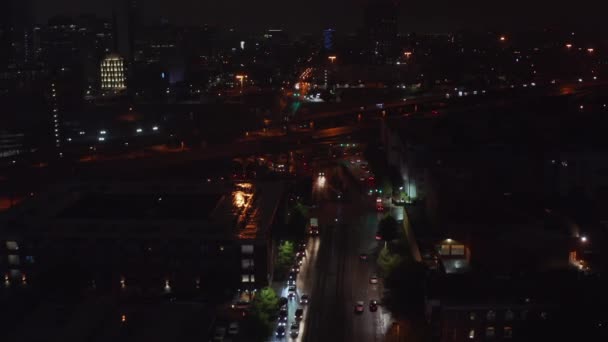 Widok z lotu ptaka na nocną scenę miasta. Dron lecący nad ulicą w kierunku autostrady wielopasmowej, pochylający się nad samochodami. Korki w nocy. Dallas, Teksas, USA — Wideo stockowe