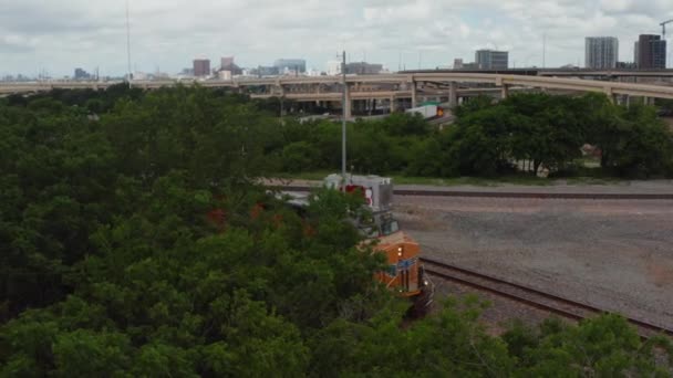 Luchtfoto van de voorkant van de diesellocomotief staat van het spoor. Panning zicht geleidelijk onthullen trein motor. Snelweg kruising op de achtergrond. Dallas, Texas, Verenigde Staten — Stockvideo