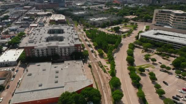 Vue aérienne du paysage urbain, inclinaison vers le haut pour montrer le panorama du centre-ville. Drone volant vers l'avant au-dessus de la voie ferrée. Dallas, Texas, USA — Video