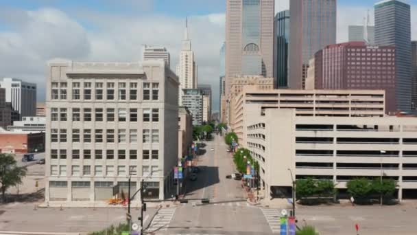 Utsikt från framåt flygande drönare ovanför gatan centrum på väg till grupp av skyskrapor. Förhöjd vy låg trafik på väg. Dallas, Texas, USA — Stockvideo